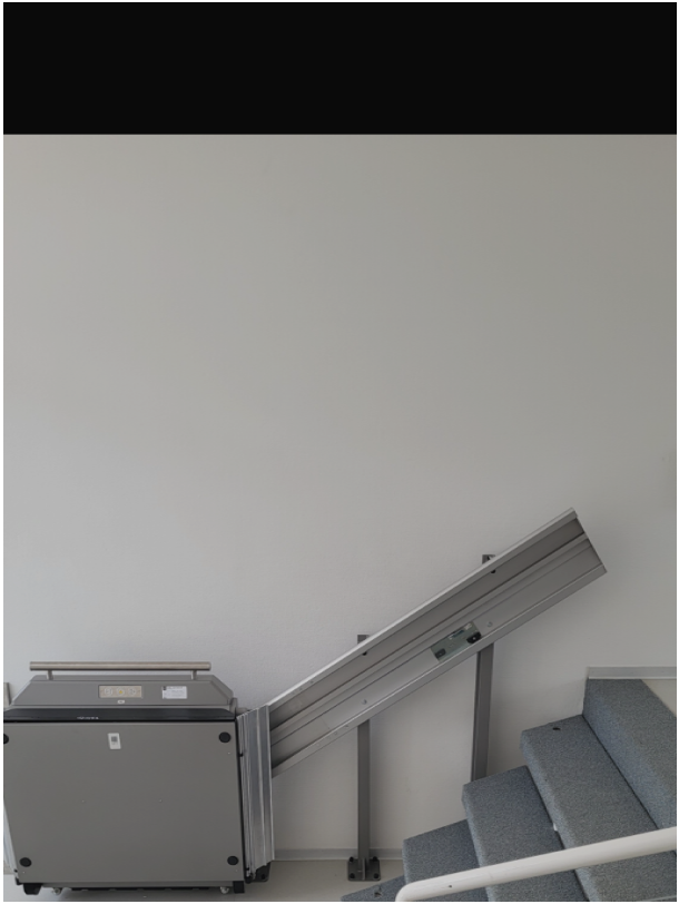Hubliftplattform, platzsparend an Wand eingefaltet und bereit zur Nutzung