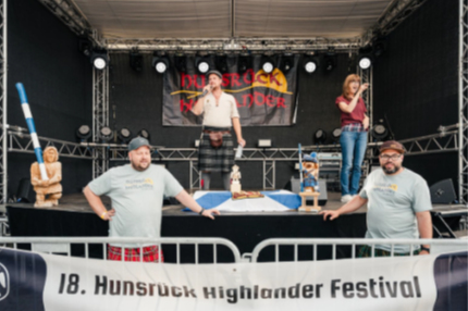 Auf der Bühne des Festivals sind ein Redner und eine Gebärdendolmetscherin zu sehen